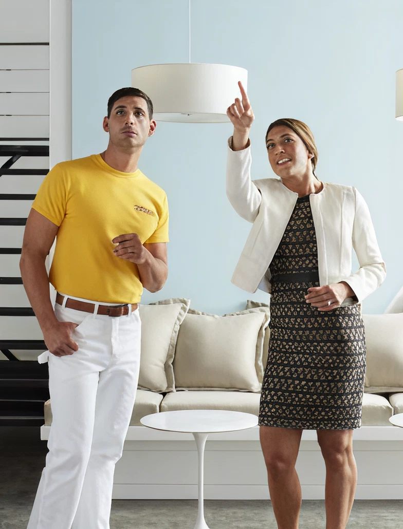 A CertaPro painter and a homeowner discussing a light fitting in her living room