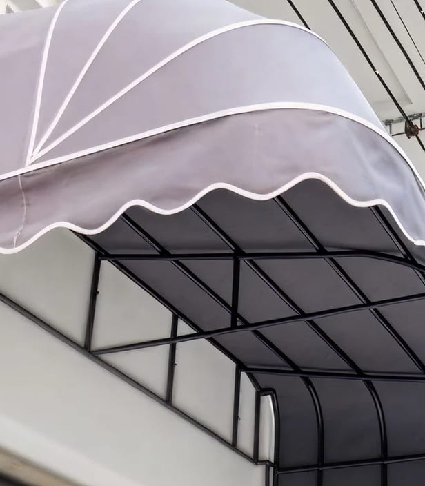A fabric awning over a black steel frame on a commercial storefront