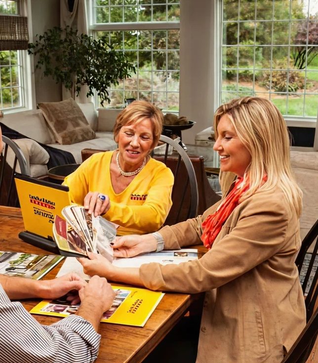 A CertaPro consultant showing paint swatches to homeowners at their table